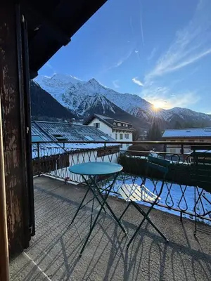 a table on a balcony with a view of mountains at Home in Chamonix Bossons in Chamonix-Mont-Blanc