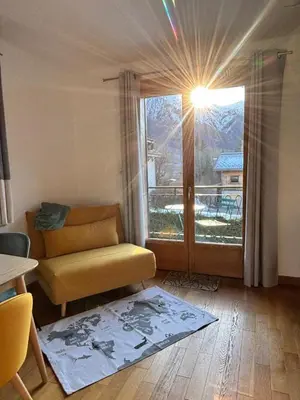 a living room with a couch and a large window at Home in Chamonix Bossons in Chamonix-Mont-Blanc