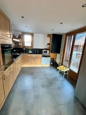 a kitchen with wooden cabinets and a tile floor at Home in Chamonix Bossons in Chamonix-Mont-Blanc