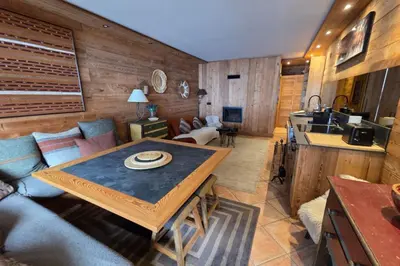 a kitchen and a living room with a table at Le Menhir Chalets de Lady in Megève
