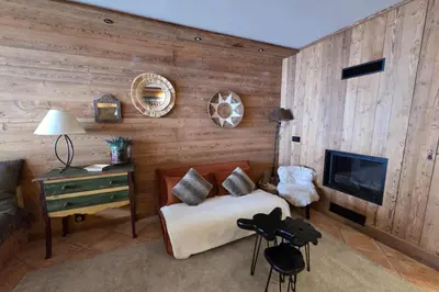 a living room with a couch and a fireplace at Le Menhir Chalets de Lady in Megève