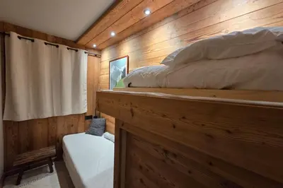 a bedroom with a bed in a wooden cabin at Le Menhir Chalets de Lady in Megève