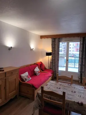 a living room with a red couch and a window at Grand Panorama-au pied du télécabine le Valléen-4pers in Saint-Gervais-les-Bains