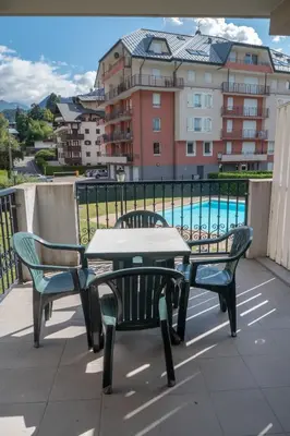 a table and chairs on a balcony with a pool at Grand Panorama-au pied du télécabine le Valléen-4pers in Saint-Gervais-les-Bains