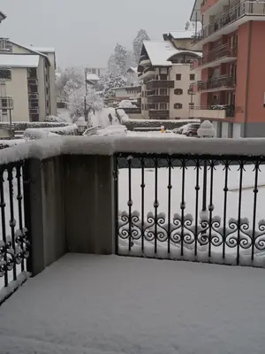a balcony covered in snow with buildings in the background at Grand Panorama-au pied du télécabine le Valléen-4pers in Saint-Gervais-les-Bains