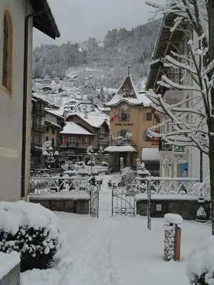 a city covered in snow with buildings in the background at Grand Panorama-au pied du télécabine le Valléen-4pers in Saint-Gervais-les-Bains