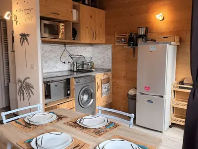 a kitchen with a table with four plates on it at Studio mezzanine ensoleillé, proche pistes, Les Carroz d'Arâches - FR-1-572-346 in Arâches-la-Frasse