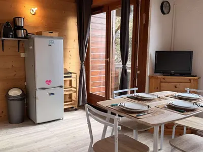 a dining room with a table and a refrigerator at Studio mezzanine ensoleillé, proche pistes, Les Carroz d'Arâches - FR-1-572-346 in Arâches-la-Frasse