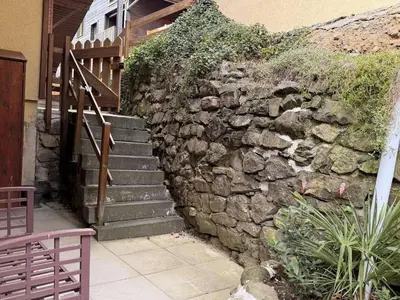 a stone wall with stairs next to a building at Studio mezzanine ensoleillé, proche pistes, Les Carroz d'Arâches - FR-1-572-346 in Arâches-la-Frasse
