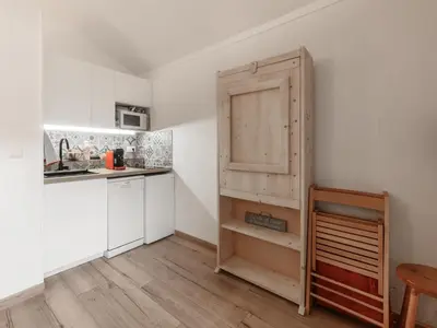 a kitchen with a wooden cabinet next to a counter at P Les Esserts N57 2P4 in Morillon