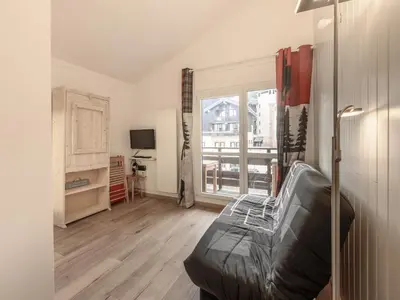 a living room with a couch and a large window at P Les Esserts N57 2P4 in Morillon