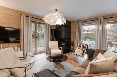 a living room with a couch and chairs and a chandelier at Kara Gypaete - Charme - Proche village in Megève