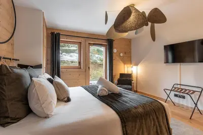 a bedroom with a large bed and a window at Kara Gypaete - Charme - Proche village in Megève