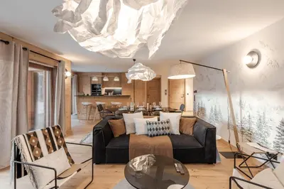 a living room with a couch and a dining room at Kara Gypaete - Charme - Proche village in Megève