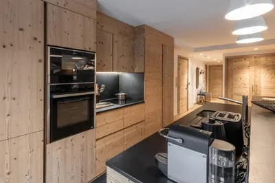 a kitchen with wooden walls and counters and a stove at Kara Gypaete - Charme - Proche village in Megève