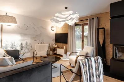 a living room with white furniture and a chandelier at Kara Gypaete - Charme - Proche village in Megève