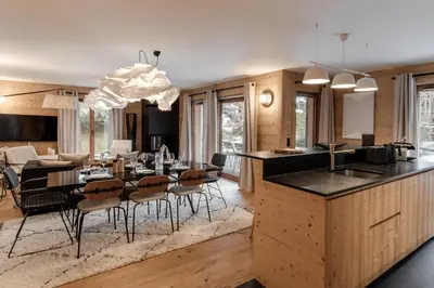 a kitchen and dining room with a table and chairs at Kara Gypaete - Charme - Proche village in Megève