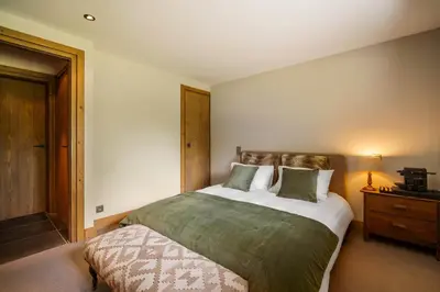 a bedroom with a large bed and a night stand at Luxury Chalet Sauna Cinema Mont Blanc Views in Megeve in Megève