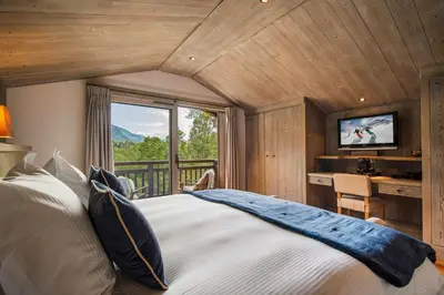 a bedroom with a large bed and a balcony at Luxury Chalet Sauna Cinema Mont Blanc Views in Megeve in Megève