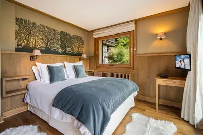 a bedroom with a large bed and a window at Luxury Chalet Sauna Cinema Mont Blanc Views in Megeve in Megève