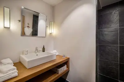 a bathroom with a white sink and a shower at Luxury Chalet Sauna Cinema Mont Blanc Views in Megeve in Megève