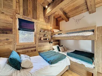 two bunk beds in a room with wooden walls at Appartement élégant 4 chambres - Combloux, proche Mont-Blanc - FR-1-560-171 in Combloux