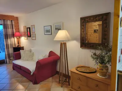 a living room with a red chair and a lamp at Les Grandes Jorasses 3 - Jardin - Vue massif Mont Blanc in Les Houches