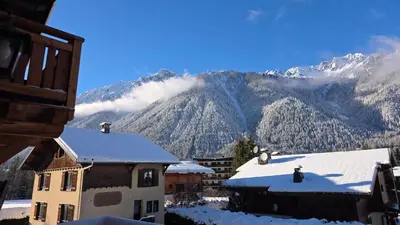 a view of a mountain with snow on the roofs of buildings at La Karabane de Clément in Chamonix-Mont-Blanc