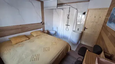 a bedroom with a large bed and a shower at La Karabane de Clément in Chamonix-Mont-Blanc