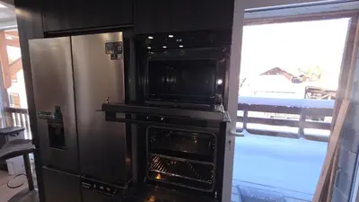 a kitchen with an oven next to a refrigerator at La Karabane de Clément in Chamonix-Mont-Blanc