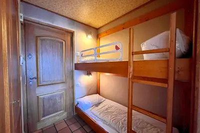 a small room with two bunk beds and a door at Stay in the mountains with stunning views in Combloux