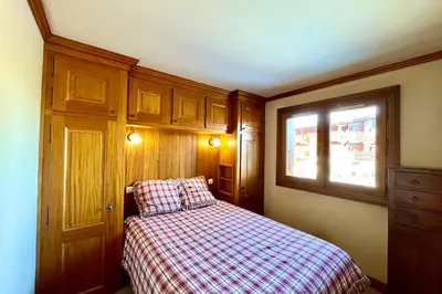 a small bedroom with a bed and a window at Stay in the mountains with stunning views in Combloux