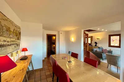 a dining room with a wooden table and red chairs at Stay in the mountains with stunning views in Combloux