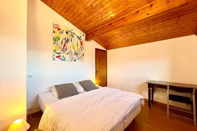 a bedroom with a bed and a wooden ceiling at Stay in the mountains with stunning views in Combloux