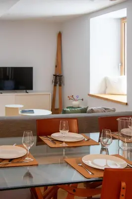 a dining room with a table with wine glasses at Appartement lumineux - 8 personnes - Wifi - Lave-linge - Au pied des pistes et des transports in Chamonix-Mont-Blanc