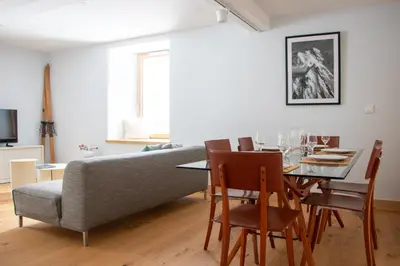 a living room with a table and a couch at Appartement lumineux - 8 personnes - Wifi - Lave-linge - Au pied des pistes et des transports in Chamonix-Mont-Blanc