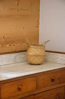 a basket sitting on top of a wooden dresser at Appartement lumineux - 8 personnes - Wifi - Lave-linge - Au pied des pistes et des transports in Chamonix-Mont-Blanc