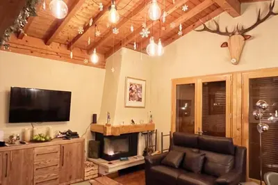 a living room with a couch and a flat screen tv at Chalet K2 in Megève