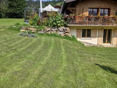a bike laying on the grass in front of a house at Chalet K2 in Megève