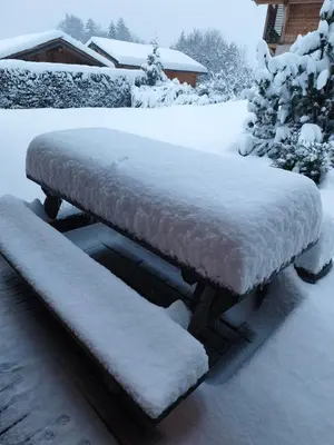 a bench covered in snow in a yard at Le pied des pistes télésiège des chattrix in Saint-Gervais-les-Bains