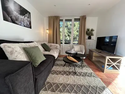 a living room with a couch and a television at Appartement Mélèzes in Megève