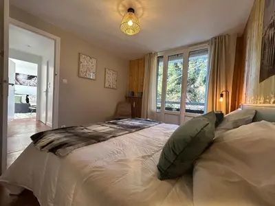 a bedroom with a large bed and a window at Appartement Mélèzes in Megève