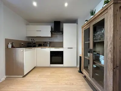 a kitchen with white cabinets and a counter top at Appartement Mélèzes in Megève