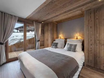 a bedroom with a large bed with wooden walls at Megève : Appartement de luxe 115m², 6 pers, accès pistes, Wifi - FR-1-569-203 in Megève