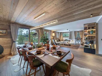 a dining room with a table and chairs and a living room at Megève : Appartement de luxe 115m², 6 pers, accès pistes, Wifi - FR-1-569-203 in Megève
