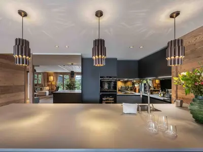 a kitchen with a large dining table and chandeliers at Megève : Appartement de luxe 115m², 6 pers, accès pistes, Wifi - FR-1-569-203 in Megève