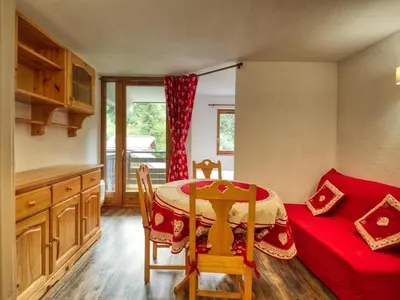 a kitchen with a table and a red couch at Bel appartement 1 chambre, coin montagne, balcon, animaux admis - FR-1-642-107 in Morillon
