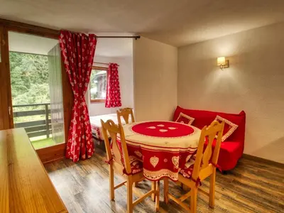 a dining room with a table and a red couch at Bel appartement 1 chambre, coin montagne, balcon, animaux admis - FR-1-642-107 in Morillon