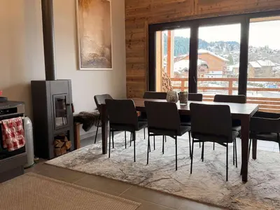 a dining room with a wooden table and chairs at Appart neuf 3 ch 8 pers près patinoire avec balcon et parking - FR-1-572-347 in Arâches-la-Frasse