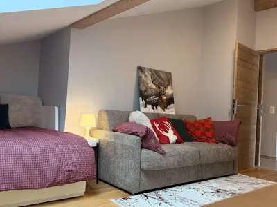 a living room with a couch and a bed at Appart neuf 3 ch 8 pers près patinoire avec balcon et parking - FR-1-572-347 in Arâches-la-Frasse